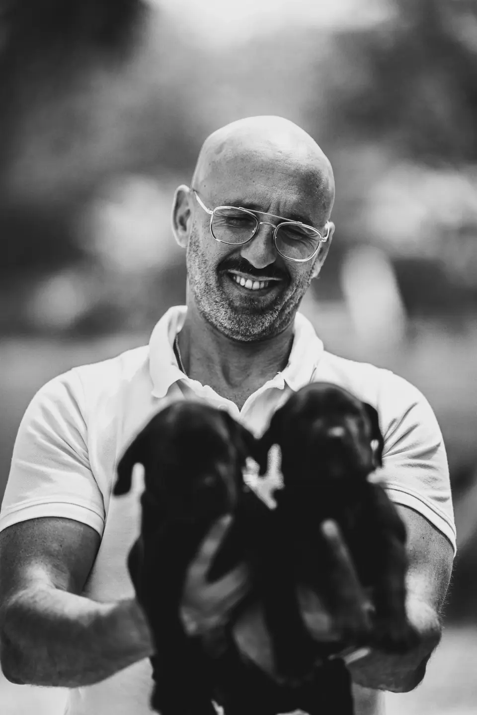Rui Navarro com dois cachorros Boerboel pretos ao colo