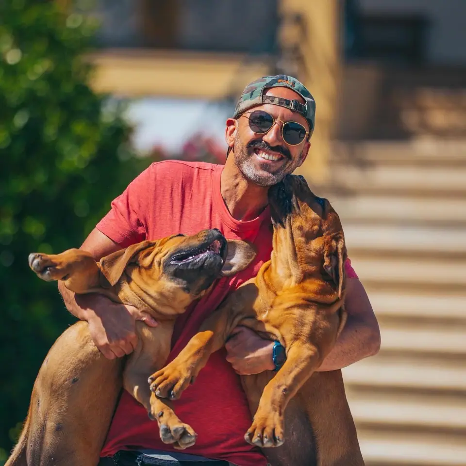 Rui Navarro a segurar dois Boerboels jovens ao ar livre